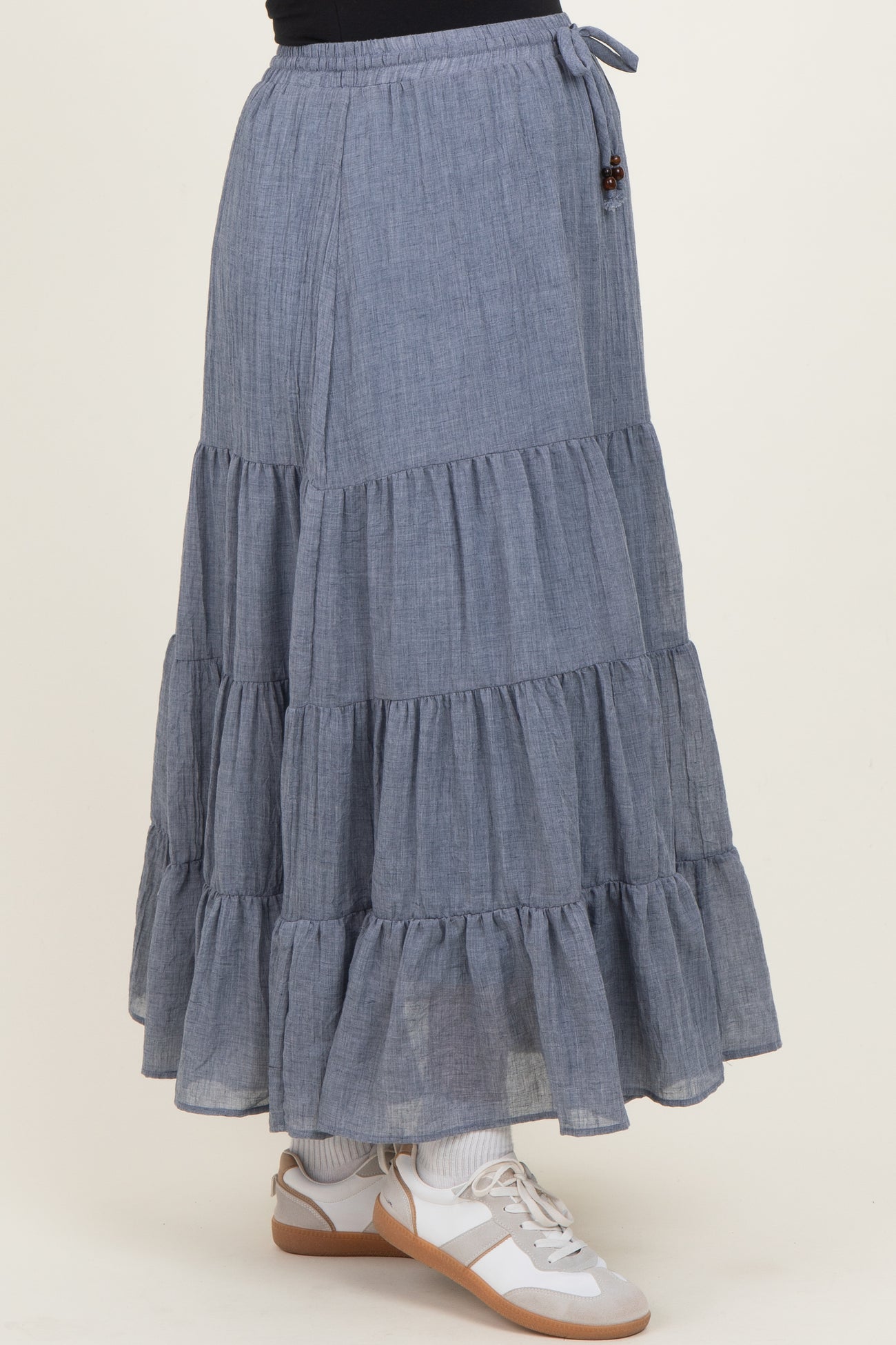 maternity wear blue tiered maxi skirt with ruffle hem details and a drawstring waistband, paired with sneakers