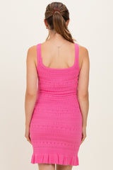 woman wearing a pink crochet maternity dress with a fitted silhouette and ruffled hemline, view from the back