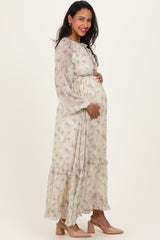 woman wearing a floral long sleeve maternity dress with a relaxed fit and ruffled hem, showing her baby bump