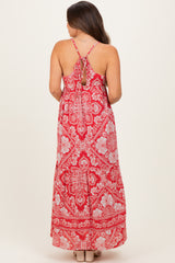 woman wearing a red floral maternity maxi dress with a tie-back detail and a flowy silhouette