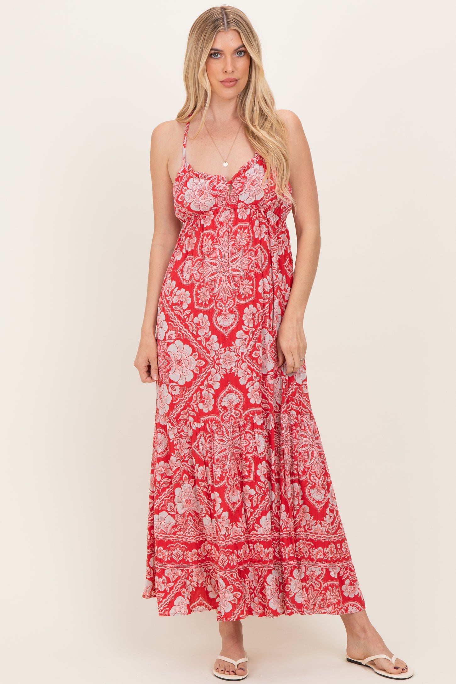 woman wearing a red floral maxi dress with spaghetti straps and a ruffled bust detail