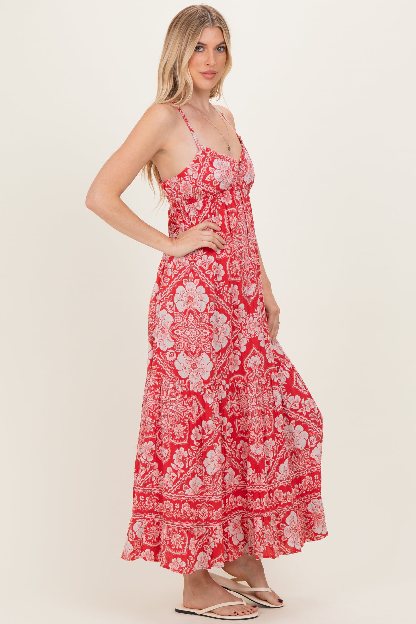 woman wearing a red floral maxi dress with adjustable straps and a flowy silhouette