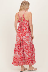 woman wearing a red floral maxi dress with a tie back and adjustable straps, showing the back view