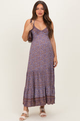 woman wearing a blue floral print maternity maxi dress with a tiered skirt and spaghetti straps