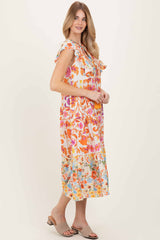 woman wearing a colorful floral midi dress with ruffle sleeves and a tiered hem