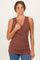 woman wearing a rust-colored sleeveless wrap tank top with a v-neck and ruching detail