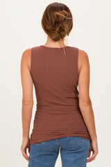 woman wearing a brown ribbed sleeveless top with a fitted silhouette and styled hair in a bun