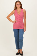 woman wearing a ribbed pink sleeveless wrap top paired with blue straight-leg jeans and black flats
