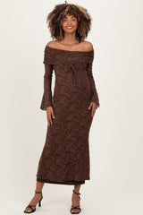 woman wearing a brown off-shoulder lace maternity dress with bell sleeves and a visible baby bump