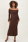 woman wearing a brown off-shoulder lace maternity dress with bell sleeves and a visible baby bump