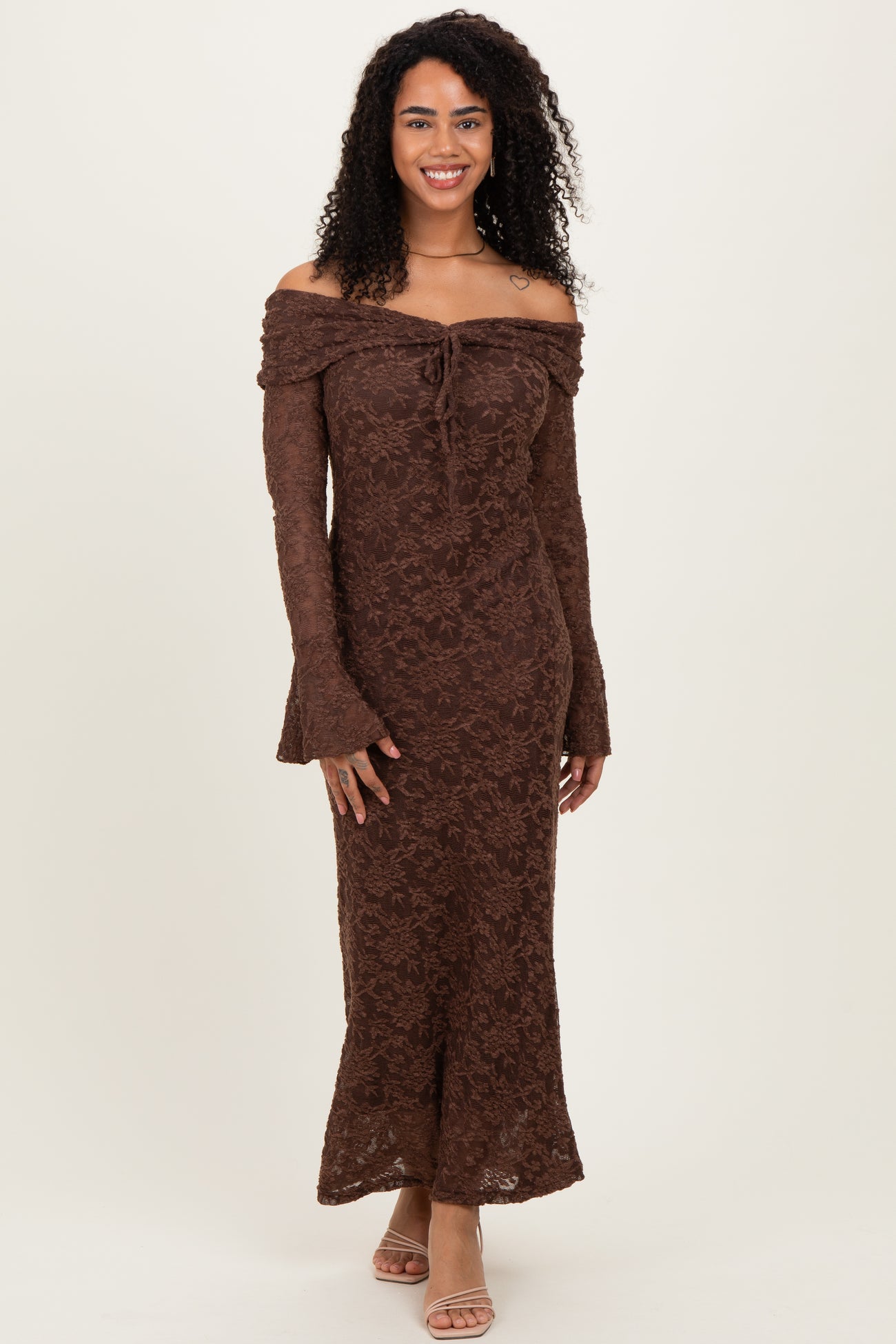 woman wearing a brown off-shoulder lace maxi dress with long sleeves and flared cuffs