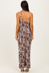 woman wearing a brown and beige patterned maxi dress with a one-shoulder design and a side slit