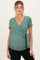 woman wearing a green maternity top with a v-neck and tie detail, accentuating her baby bump