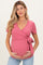 woman wearing a pink short sleeve maternity wrap top and holding her baby bump