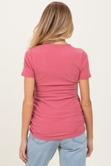 woman wearing a pink ribbed maternity top with ruching on the back, showcasing a comfortable fit