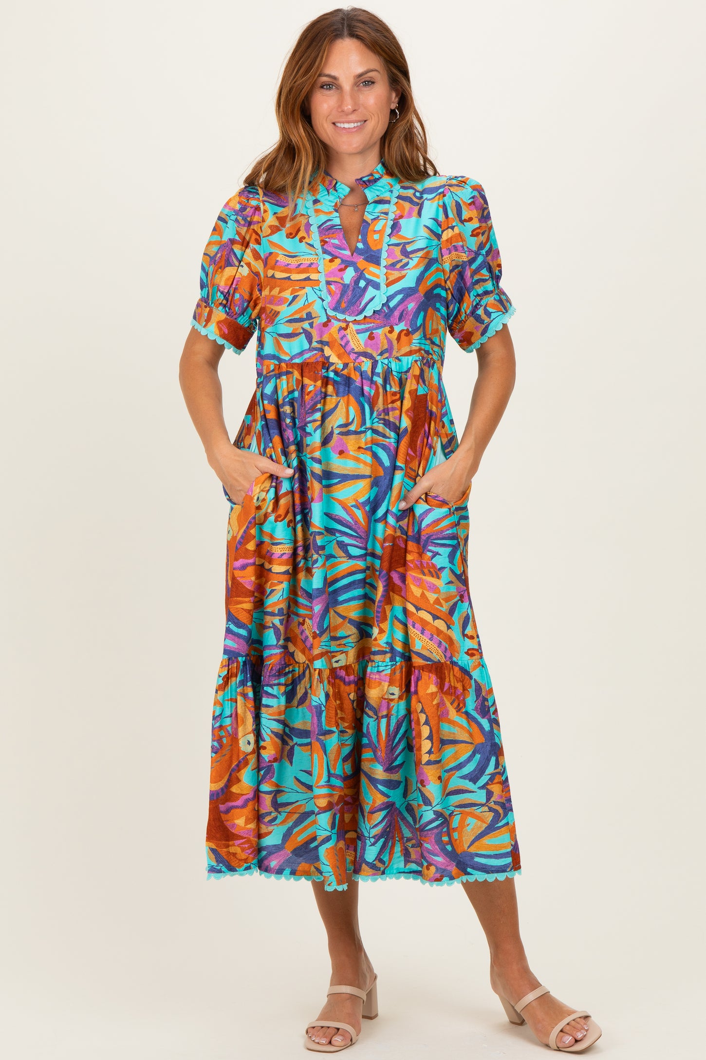 woman wearing a colorful floral print midi dress with short sleeves and pockets
