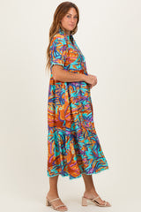 woman wearing a colorful tropical print midi dress with short sleeves and ruffle hem