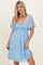 woman wearing a light blue lace short dress with flutter sleeves and a gathered waist