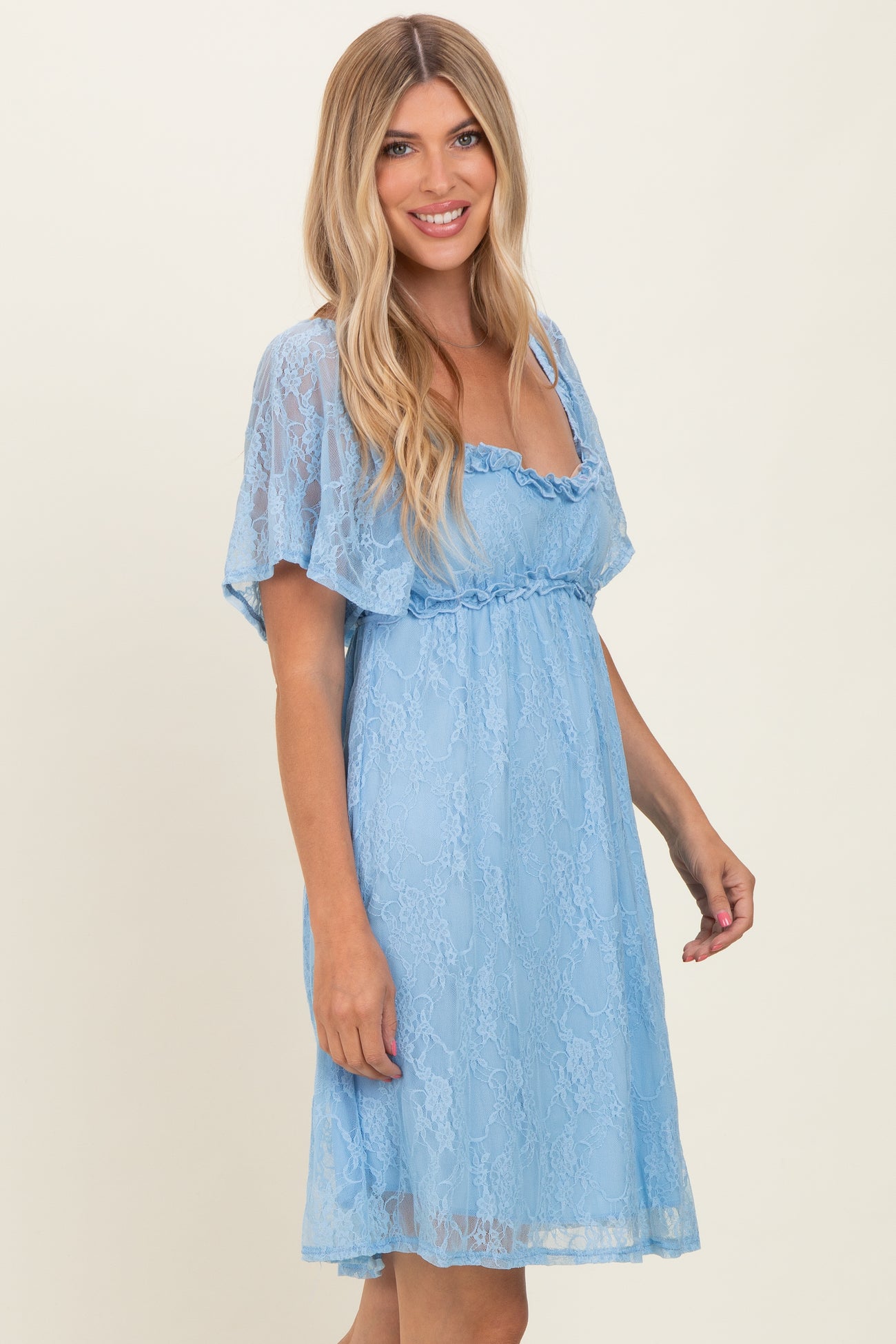 woman wearing a light blue lace dress with flutter sleeves and a fitted waist