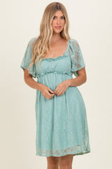 woman wearing a light blue lace dress with short sleeves and a ruffled neckline
