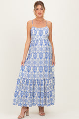 woman wearing a blue and white patterned maternity maxi dress with spaghetti straps and a ruffled hem