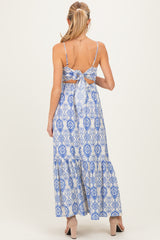 woman wearing a blue and white patterned maternity maxi dress with adjustable spaghetti straps and a tie-back detail