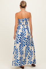 woman wearing a strapless blue and white floral maxi maternity dress, back view