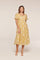woman wearing a yellow tiered midi dress with white floral embroidery and short puff sleeves