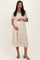 woman wearing a cream floral maternity dress with short sleeves and a gathered waist, holding her baby bump