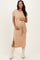 woman wearing a beige maternity dress with a tie waist and side slits, holding her baby bump