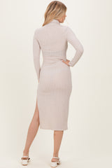 woman wearing a light beige ribbed midi dress with long sleeves and a side slit, viewed from the back