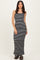 woman wearing a black and white striped maxi dress with thin straps and a fitted silhouette