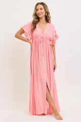 woman wearing a pink maxi dress with ruffle sleeves and a front slit, styled with a v-neckline and button details