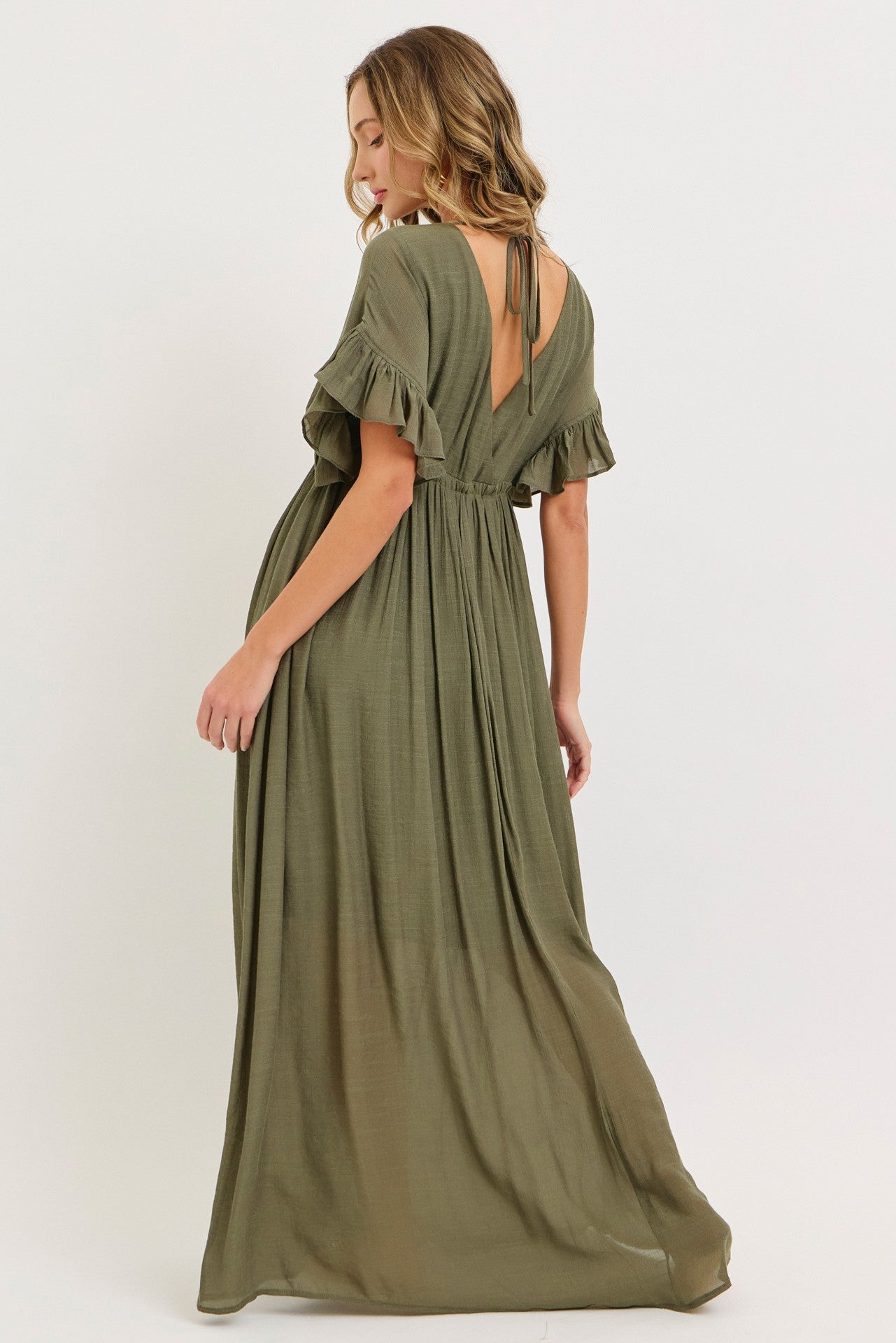 woman wearing an olive green maxi dress with flutter sleeves and a tie back detail