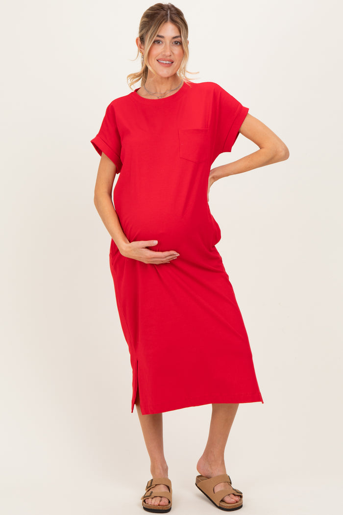 woman wearing a red short sleeve maternity dress with a pocket, holding her baby bump