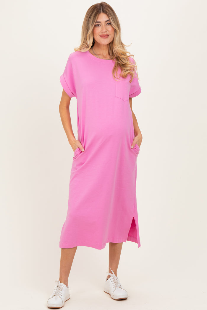 woman wearing a hot pink maternity t-shirt dress with short sleeves and pockets, showcasing her baby bump
