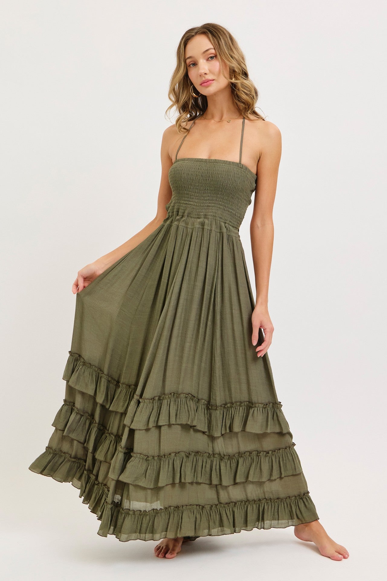 woman wearing a sage green strapless maxi dress with ruffle tiers and a smocked bodice