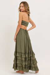 woman wearing a green two-piece set with a smocked crop top and a tiered maxi skirt, shown from the back
