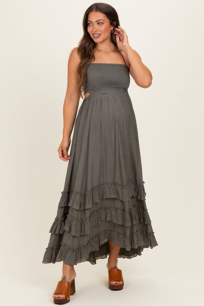 woman wearing a dark olive green strapless maternity maxi dress with ruffle details and a visible baby bump