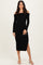 woman wearing a black off-the-shoulder long sleeve dress with a side slit and fitted silhouette