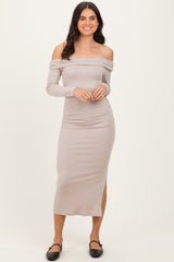 woman wearing a taupe off-the-shoulder midi dress with long sleeves and side slit, standing against a neutral background