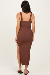 woman wearing a brown ribbed maxi dress with lace straps and a side slit, standing with her back to the camera