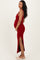 woman wearing a red maternity maxi dress with a side slit and holding her baby bump