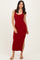 woman wearing a red ribbed midi dress with a scoop neckline and side slit, standing on a neutral background
