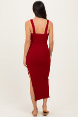 woman wearing a red ribbed midi dress with lace trim and a side slit, shown from the back