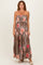 woman wearing a strapless maxi dress with a leopard print and floral design in brown and pink tones