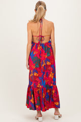 woman wearing a vibrant red floral maternity maxi dress with a halter neck and back tie detail