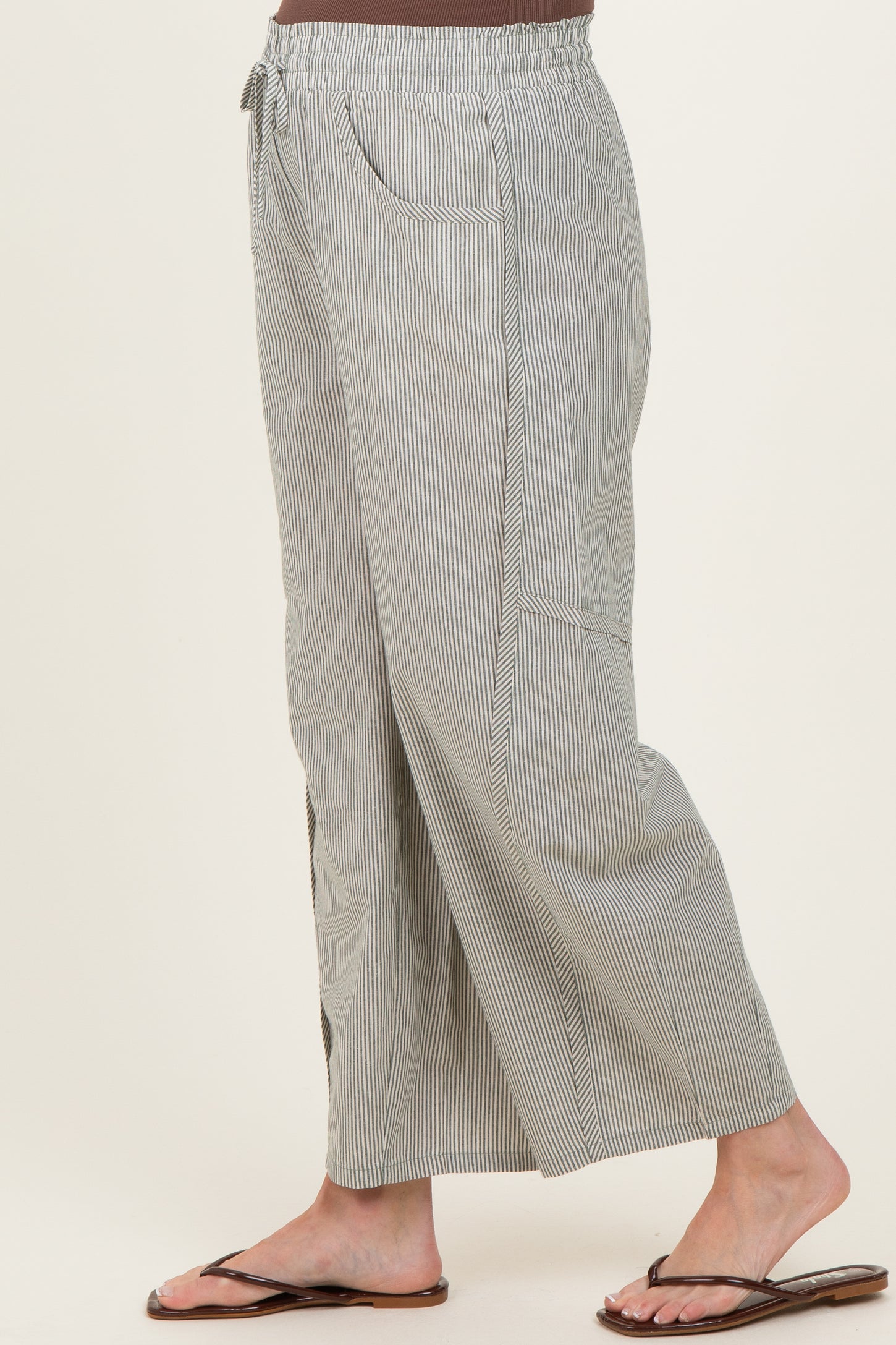 woman wearing maternity pleated wide-leg striped pants with an elastic waistband and side pockets