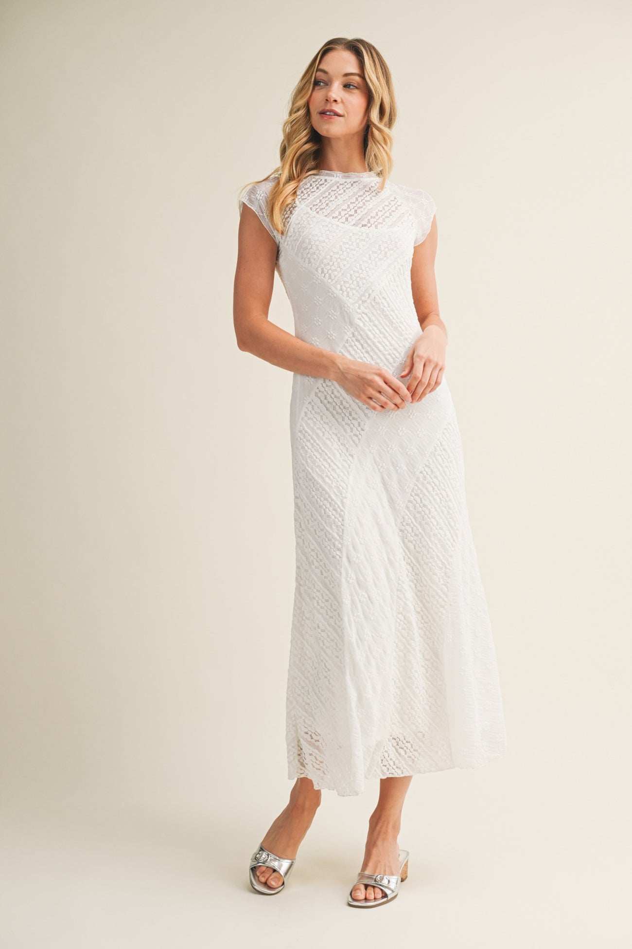 woman wearing a white lace maxi dress with short sleeves and a fitted bodice