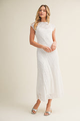 woman wearing a white lace maxi dress with short sleeves and a fitted bodice